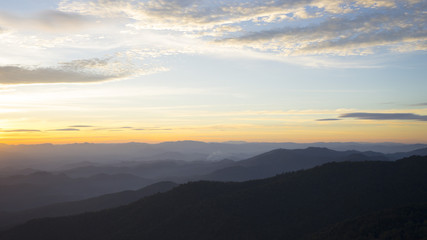 Obraz premium Panoramic scenery of the mist shrouded mountains at sunset