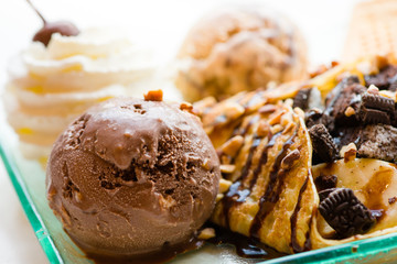 tasty pancakes with chocolate ice cream crispy waffle whipped cream with brownies cherry almond and chocolat syrup on top.served pancakes crepes on plate.sweets dessert brownies pancakes crepes.