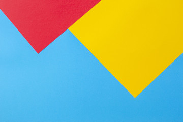 Color papers geometry flat composition background with yellow red and blue tones