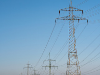 Electricity Pylons and Lines against blue sky background.