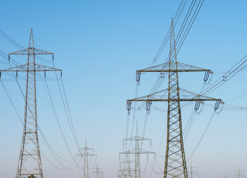 Electricity Pylons and Lines against blue sky background.