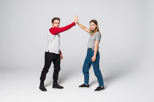 Portrait Of A Cheery Young Couple Giving High Five Over White Background