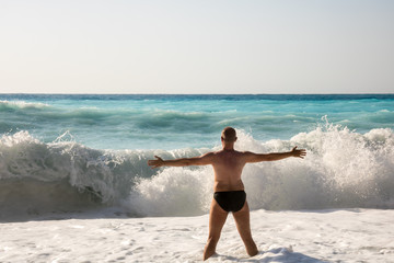 Man chasing the waves on Myrtos beach, island Kefalonia, Greece