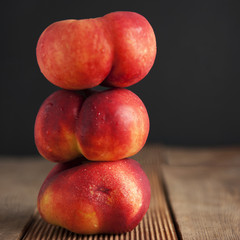 Fototapeta na wymiar Peaches and Nectarines fruits. Concept for healthy nutrition. Dark black background and wooden table. Isolated. Square iamge.
