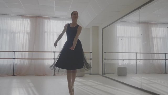 Ballerina dancing in studio in front of mirror