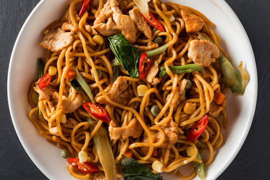 wok stir-fry egg noodles with fried chicken and thai spices and, traditional spicy asian cuisine food