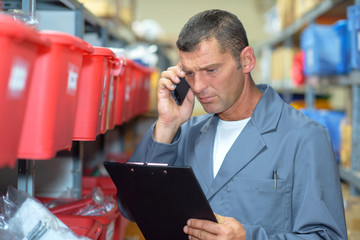 Man in warehouse on telephone looking concerned