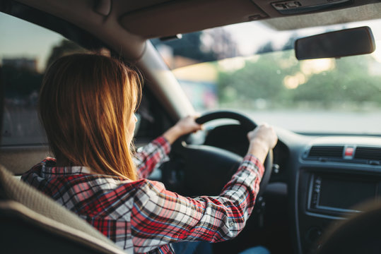 Young Woman Beginner Driving A Car, Back View