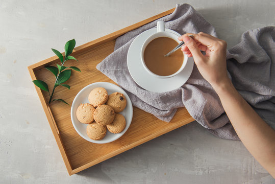 Close Up Of Cookie And Hand Stirring Cup Of Tea/coffee