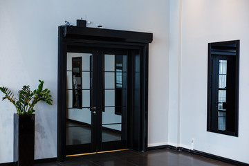 Corner room with a wooden wall, an aged floor, black glass doors and dressing mirror
