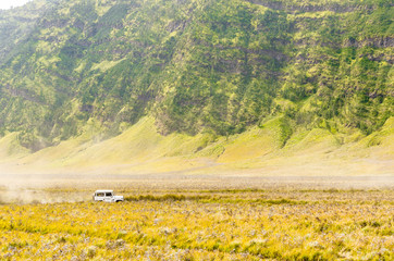 a car run cross savana and creat sand smoke in mount bromo, indonesia