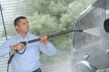 Fototapeta na wymiar handsome man is cleaning car outdoor