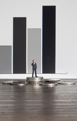 Business concept. Businessman standing on a pile of silver coins.