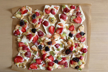 Frozen yogurt bark with various fruit strawberry, banana, nectarine, kiwi, raspberry, blackberry...