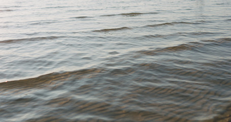 Obraz premium small waves on sandy sea beach on a sunny day