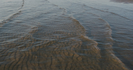 small waves on sandy sea beach on a sunny day