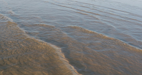 small waves on sandy sea beach on a sunny day