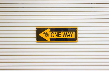 One way sign against a wall background