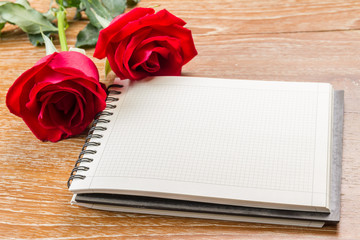 red rose and blank notebook