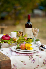 Lunch in the garden with wine and fruit. Romantic dinner in the open air. Autumn leaves of flowers. Beautiful table scrapbooking