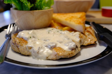 Dinner, grilled chicken breast with white sauce.