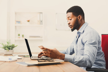 Young black businessman using mobile phone