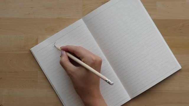 Student write Chinese character in notebook with pencil