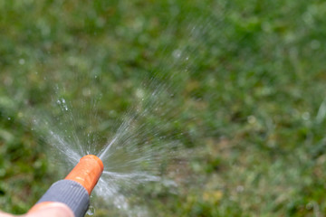 Spitzendes Wasser aus einem Gartenschlauch im Garten