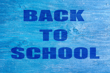 Back to school. The inscription on a blue wooden background. Education.