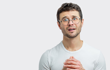 please. foregive me. young man with wide open eyes feels contrition. male feels sorrow for sins....