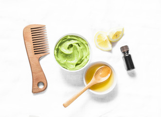 Avocado, honey hair homemade mask on light background, top view. Natural products for hair health and beauty