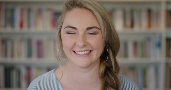 portrait happy young blonde woman student laughing enjoying relaxed lifestyle independent female in library bookstore background