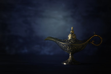 Image of magical mysterious aladdin lamp over black background. Lamp of wishes.
