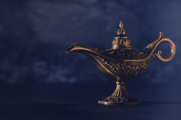 Image of magical mysterious aladdin lamp over black background. Lamp of wishes.