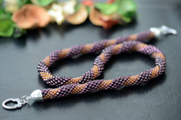 Spiral beaded necklace two colors on a dark background close up