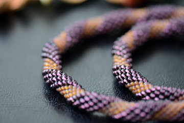 Spiral beaded necklace two colors on a dark background close up