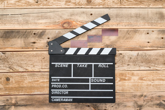 Cinema clapper board and of film on wood