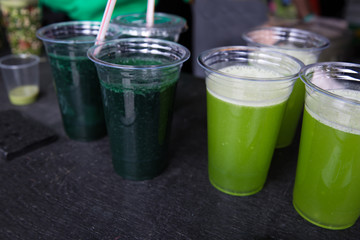 Green smoothie cocktail with spirulina, chlorella and alga on wooden background. Healthy veggy summer detox food.