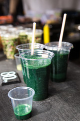 Green smoothie cocktail with spirulina, chlorella and alga on wooden background. Healthy veggy summer detox food.