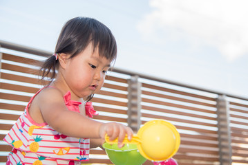バルコニーで水遊びをする子供