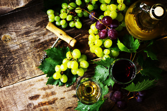 Wine background. White and red wine in glasses, bottle, grapes on vintage background, wine concept. Copy space.