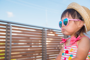 麦わら帽子とサングラスをつけた子供