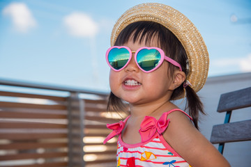 麦わら帽子とサングラスをつけた子供