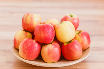 red ripe apples on a wooden plate