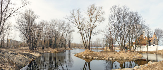 Fototapeta na wymiar Spring naked trees on riverbank in Dnepropetrovsk, Ukraine.