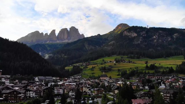 Aerial view from drone Campitello Di Fasa, Dolomites, Italy. Rocky mountains in the background. Italian Dolomites Mountains Village.  Canazei