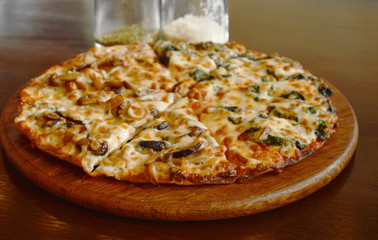 pizza topping mushroom and spinach cheese on wooden plate with seasoning bottle