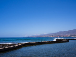 Empty jetty leading out to sea at Playa de Las Americas, Tenerife, Spain