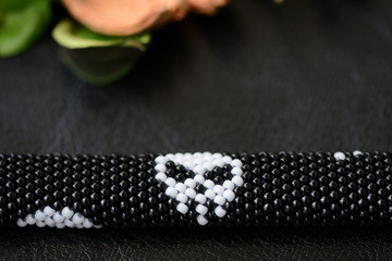 Beaded bracelet with a skull print on a dark background close up