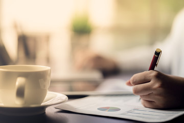 The accountant checking documents about graph and chart relating to financial reporting and tax accounting of the company